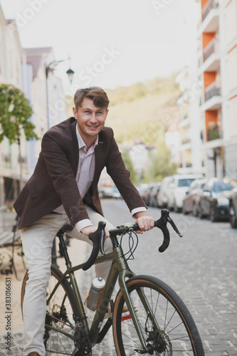 Vertical shot of a happy middle aged man smiling, sitting on his bicycle
