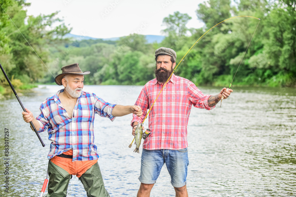 Hobby Heaven. Big game fishing. friendship. hunting tourism. father and son fishing. Camping on the shore of lake. two happy fisherman with fishing rod and net. Fly Fishing Time. hobby Hobby Heaven. Big game fishing. friendship. hunting tourism. father and son fishing. Camping on the shore of lake. two happy fisherman with fishing rod and net. Fly Fishing Time. hobby