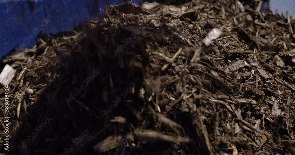 Mulch being dumped into wheelbarrow - close up - slow motion Mulch being dumped into wheelbarrow - close up - slow motion