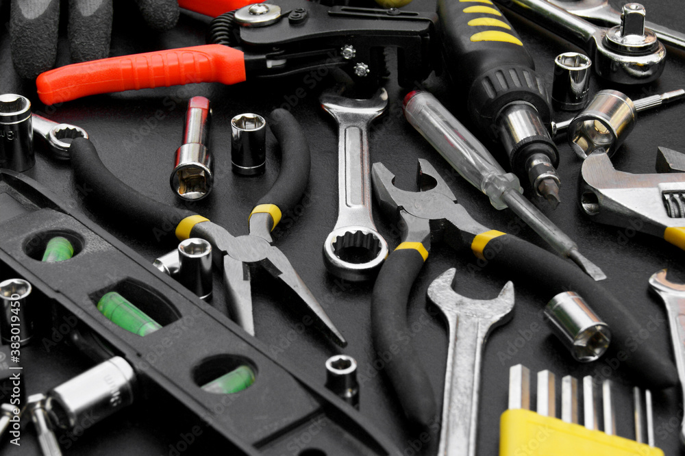 Fototapeta premium Many different tools for repair work on a black background.