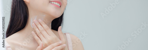 Closeup beautiful young asian woman applying cream on neck and message, beauty girl applying lotion skin care for health and soft hydration, treatment and cosmetic with moisturizer, banner website.