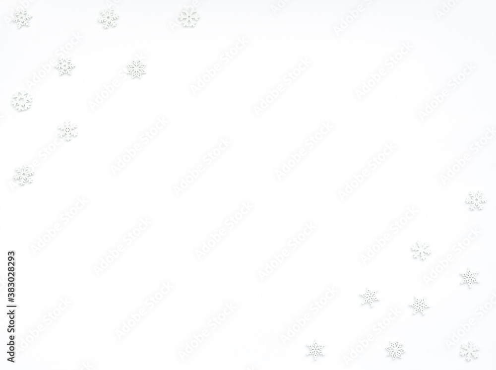 Fototapeta premium Christmas or winter white background with small white wooden snowflakes. New Year greeting card. Christmas, New Year or winter concept. Flat lay style with copy space.