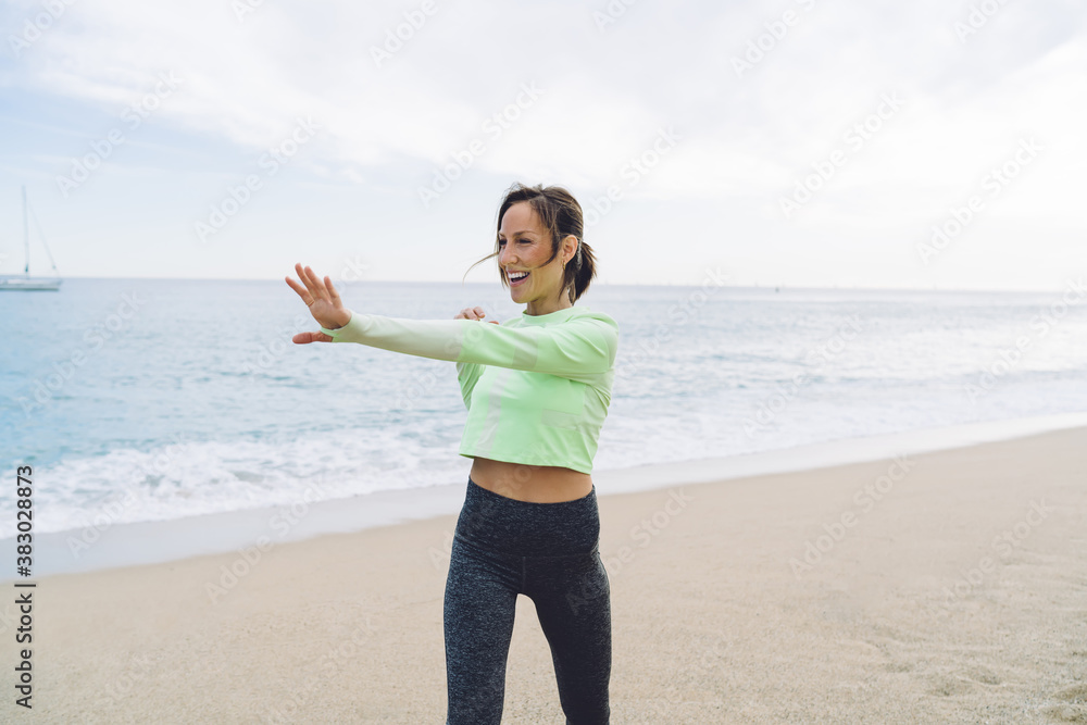 Happy Caucasian female runner warm up arms muscles before seashore cardio training for keeping perfect body shape,motivated fit girl training muscles enjoying healthy lifestyle and physical recreation Happy Caucasian female runner warm up arms muscles before seashore cardio training for keeping perfect body shape,motivated fit girl training muscles enjoying healthy lifestyle and physical recreation