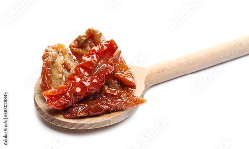 Oiled sun-dried tomatoes with wooden spoon isolated on white background