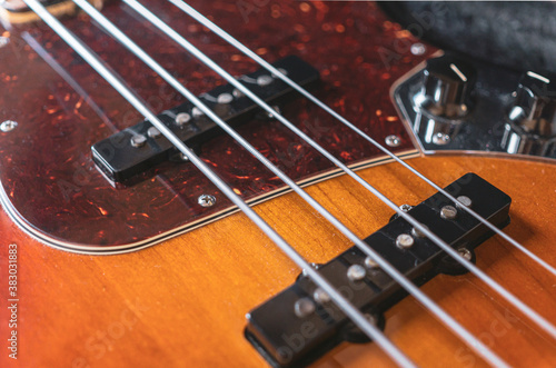 Close-up photo of the strings, pickups and pickguard of a Jazz Bass Guitar photo