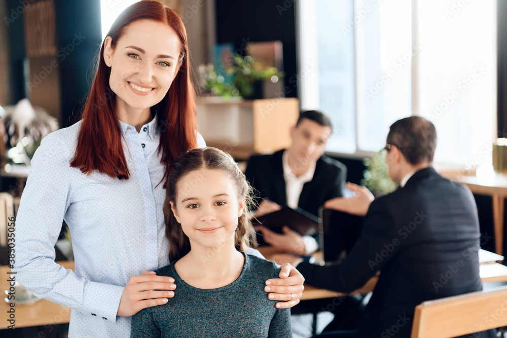 Fototapeta premium Woman is standing in foreground and hugging girl