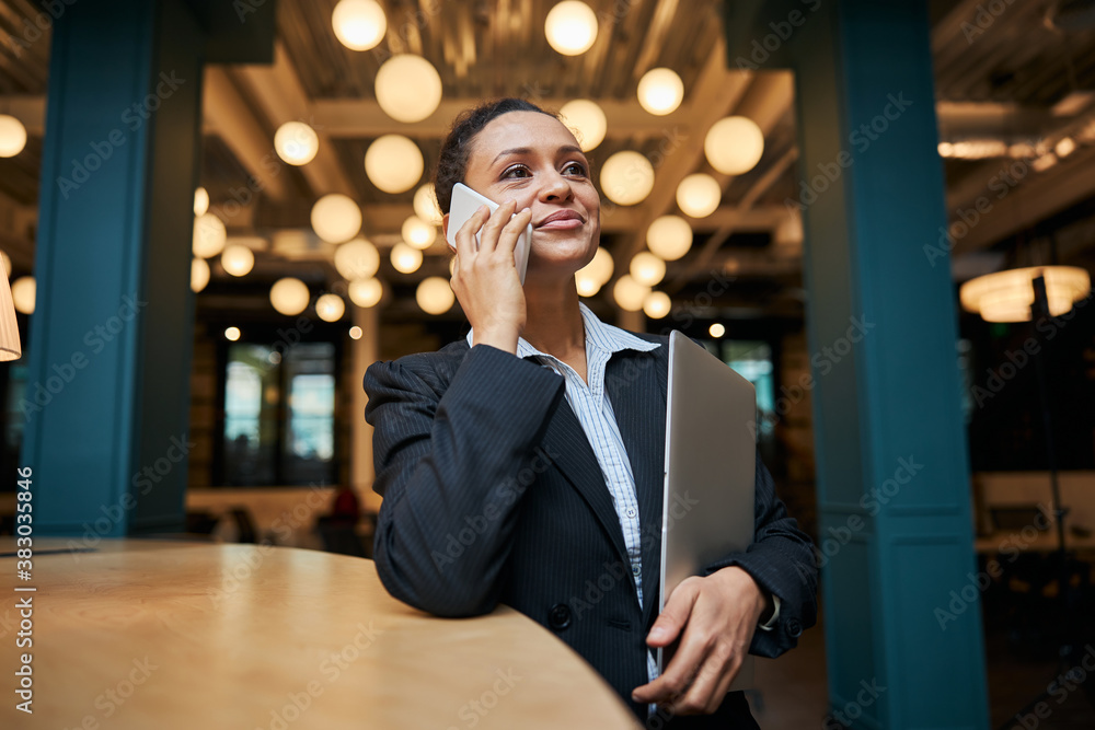 Pleased brunette woman standing at the table Pleased brunette woman standing at the table