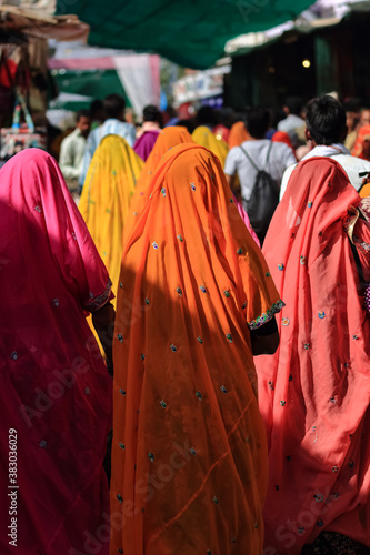 A Selective focus image of a group of Indian women wearing traditional clothes with vibrant colors at Pushkar, Rajasthan, India on 19 November 2018