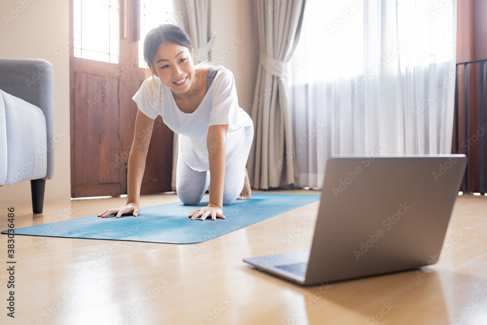 Woman relaxing with yoga at home by following online tutorial. Woman relaxing with yoga at home by following online tutorial.