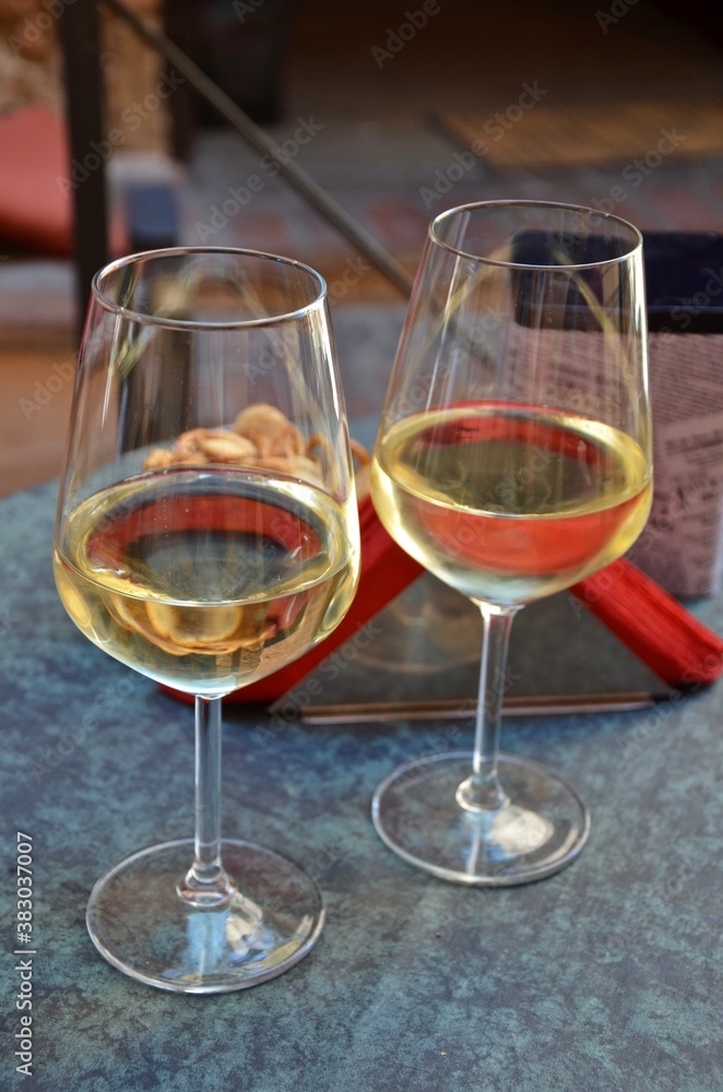 Two glasses of white wine on a vintage table, blurred background