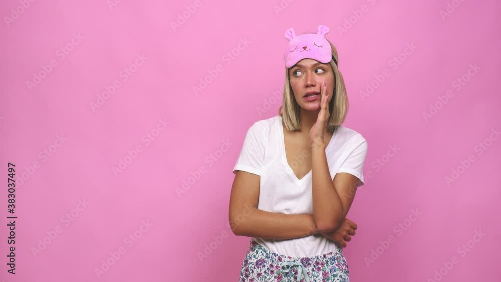 Young cute woman wearing pajama is saying a secret hot braking news and looking aside Young cute woman wearing pajama is saying a secret hot braking news and looking aside