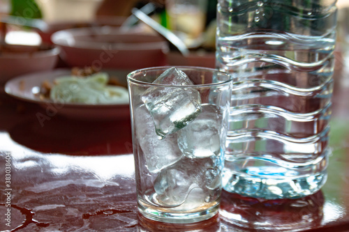 ice glass and drinking water bottle, water glass and ice cubes