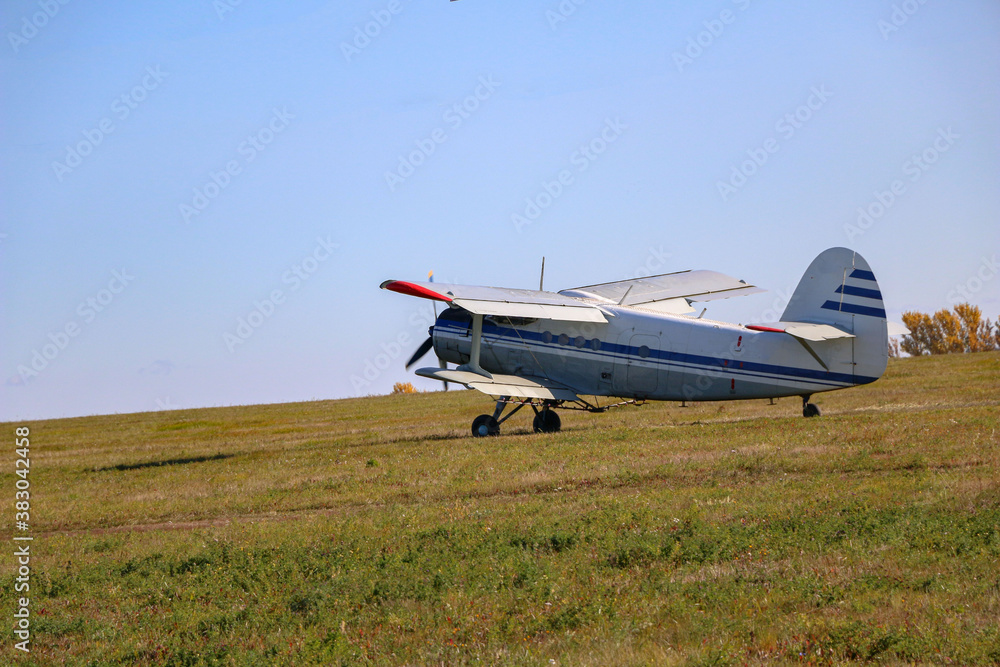 small biplane, an agricultural maize plane, with a special diffuser for field fertilizers and pesticides, picks up speed and takes off over the autumn field. small biplane, an agricultural maize plane, with a special diffuser for field fertilizers and pesticides, picks up speed and takes off over the autumn field.