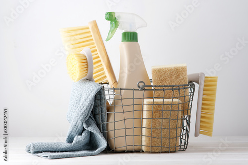 Eco brushes, sponges and rag in cleaning basket. Cleaner concept on white background photo