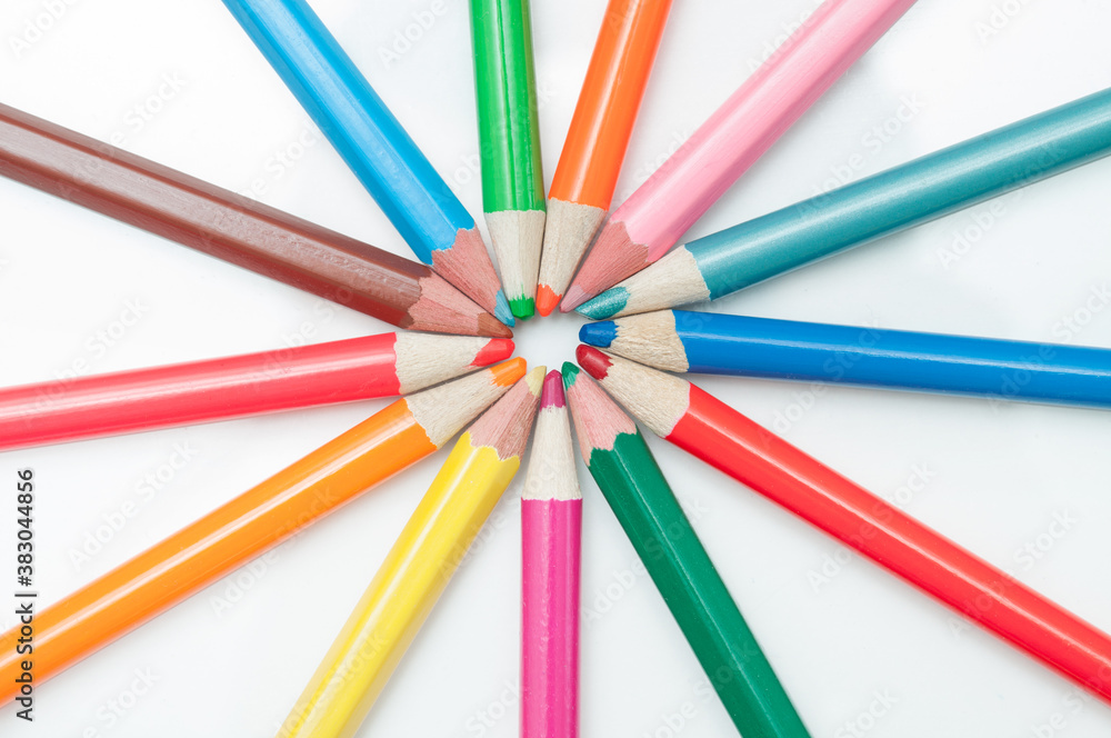 Colored pencils on a white background, pointing at the center of the frame.