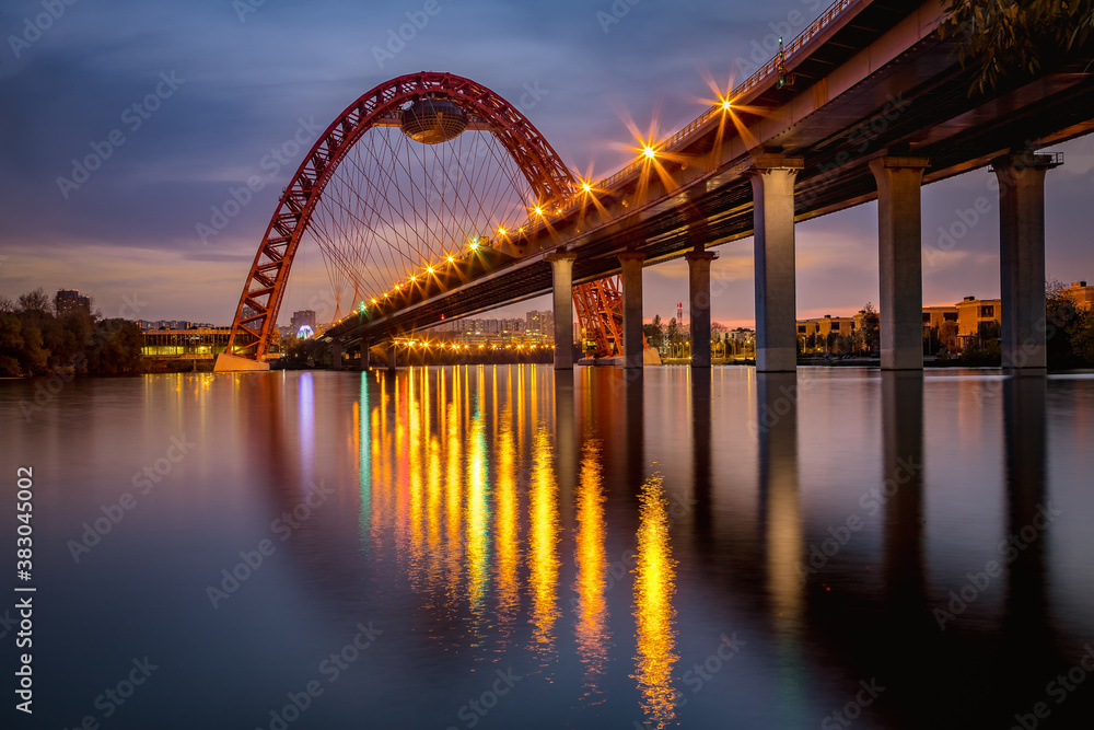 A photo of a picturesque bridge over the Moscow river against the sunset sky.