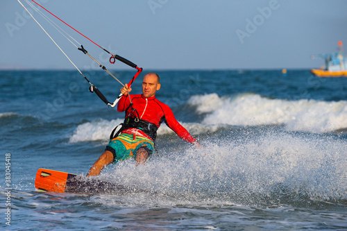 Kitesurfing on the waves of the sea in Mui Ne beach, Phan Thiet, Binh Thuan, Vietnam. Doing the trick - pop