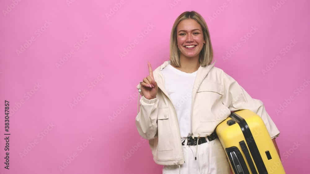 Young blonde woman ready for a travel showing number one with finger Young blonde woman ready for a travel showing number one with finger