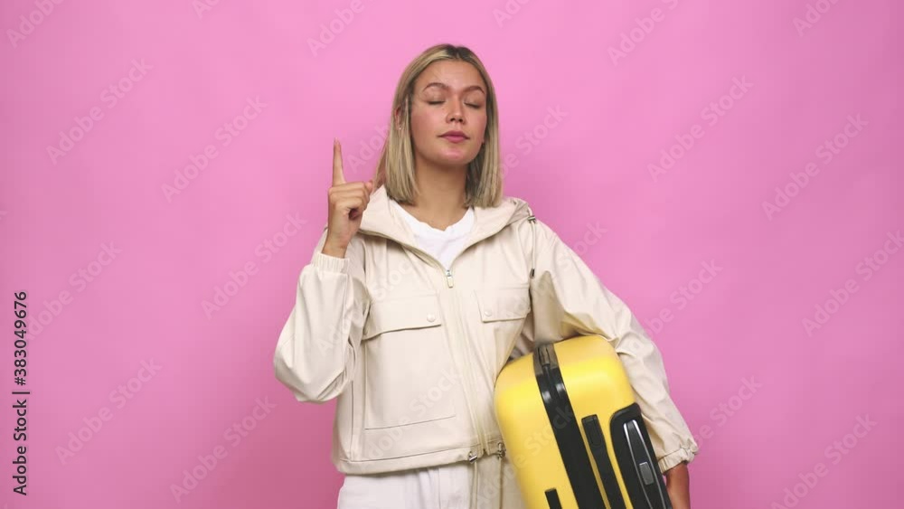Young blonde woman ready for a travel pointing upside with opened mouth Young blonde woman ready for a travel pointing upside with opened mouth