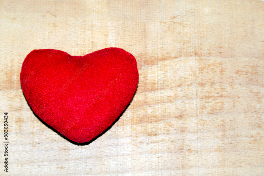 Fototapeta premium red plush heart on a wooden background.