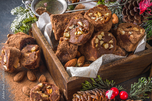 Traditional italian winter and Christmas dessert. Homemade chocolate salami sausage, on festive background with Christmas decoration