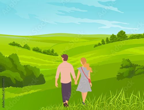 Young romantic couple walks in park or field. Grass in the foreground, bushes, thickets, valley. Walking the countryside, tourist route, picturesque landscape with young married couple or teenagers