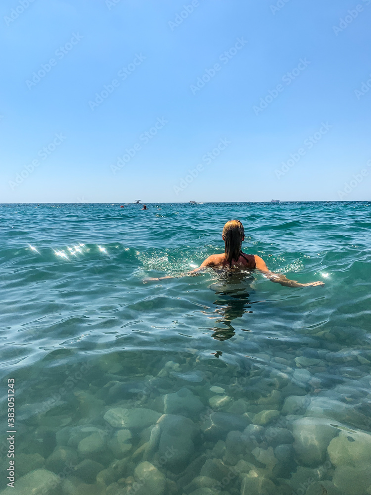 Woman back in the blue sea background