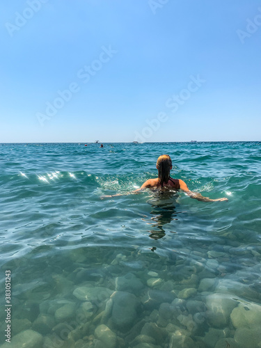 Woman back in the blue sea background © Oksana