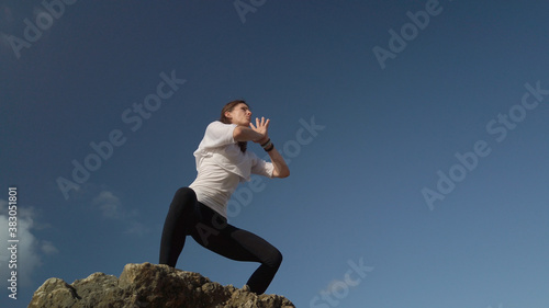 Young caucasian woman brunette doing yoga against blue sky. High quality photo photo