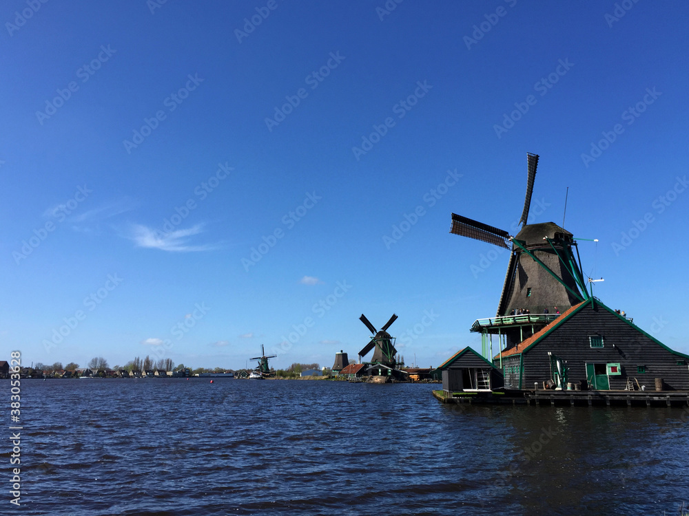 dutch historic windmills near sea coast at blue sky, in Zaanse Schans, North Holland, Netherlands