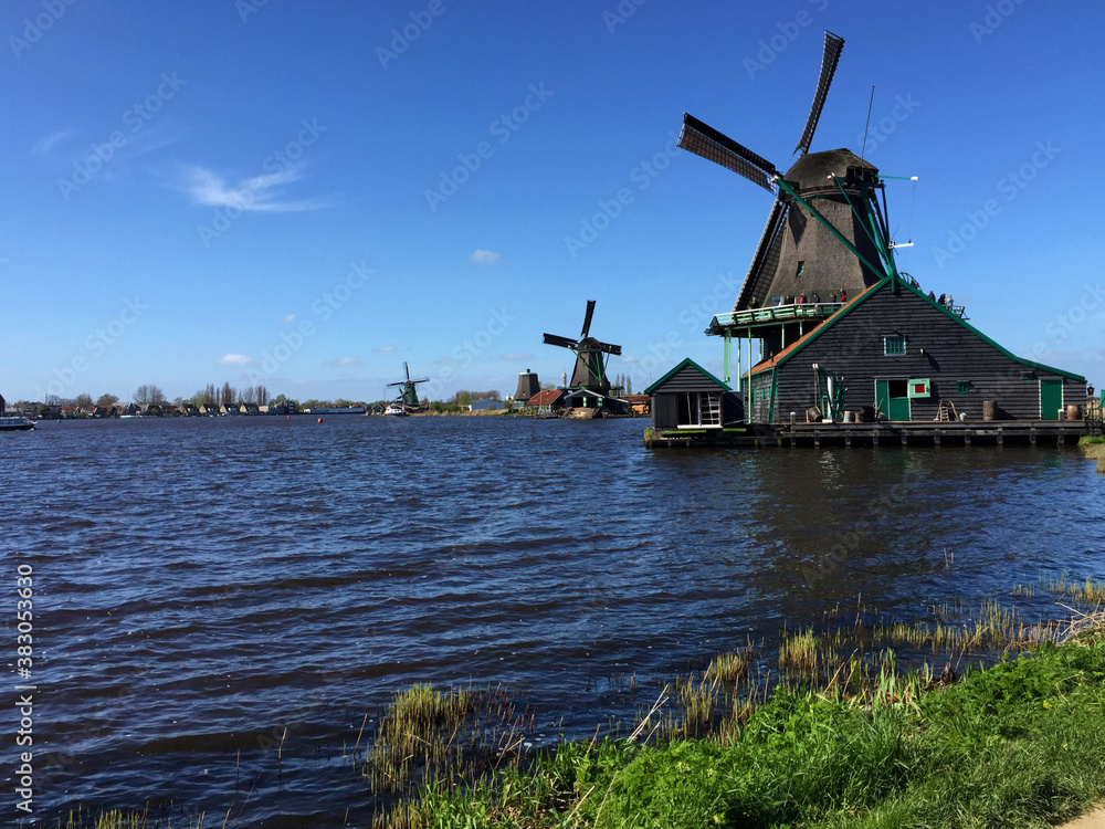 dutch historic windmills near sea coast at blue sky, in Zaanse Schans, North Holland, Netherlands