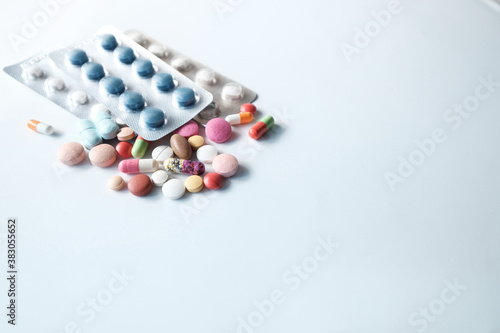 close up of colorful pills spilling on white background 