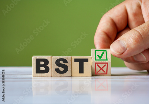hand turn wooden block with red reject X and green confirm tick as change concept of BST. Word BST conceptual symbol.