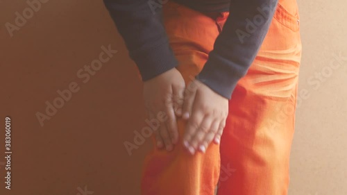 Knee pain, health care concept. Child massaging painful leg. Kids joint ligament problem, knee ache exercise. Stretching muscles fatigue to relieve pain. Sports injuries. School physical training 4K.