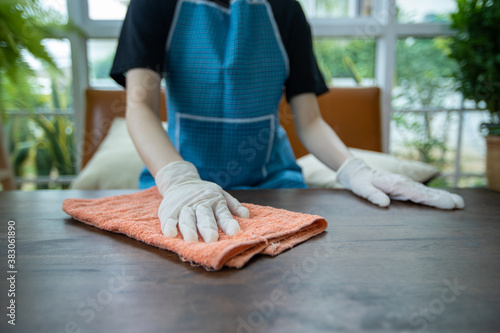 Asian women wearing glove and Cleaning table at home