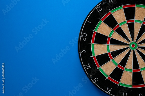 target dart board on the blue table background, center point, head to target marketing and business success concept
