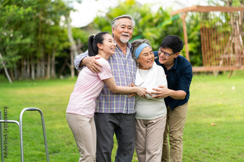 Asian family with love. 4 People. happy family shows love by hugging each other on the lawn at home. © NVB Stocker