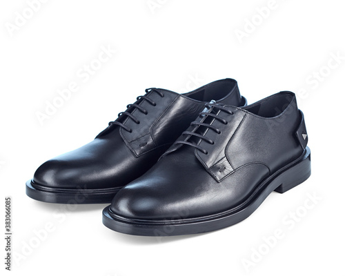  Beautiful pair of classic men's black leather shoes on lace, complemented by imitation spurs on the heel, isolated on a white background with a shadow.