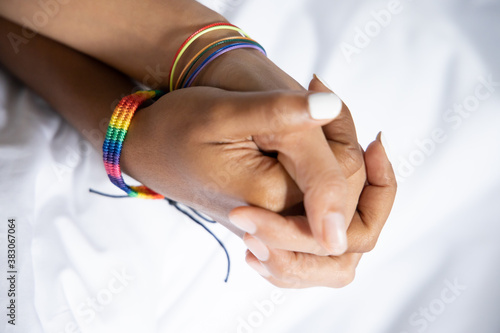 hand of black african LGBT woman holding with asian LGBT woman, gay pride concept
