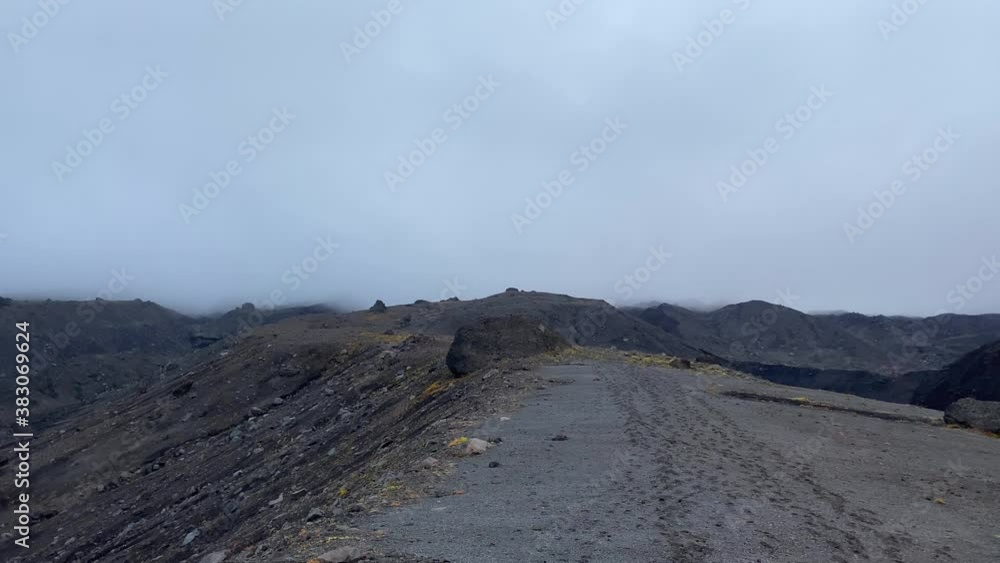 Aerial view of endless lava plains in the area of Klyuchevskoy Volcano Park. Travel to the Kamchatka Peninsula. A beautiful remote volcanic mountain site in fog. Aerial view of endless lava plains in the area of Klyuchevskoy Volcano Park. Travel to the Kamchatka Peninsula. A beautiful remote volcanic mountain site in fog.
