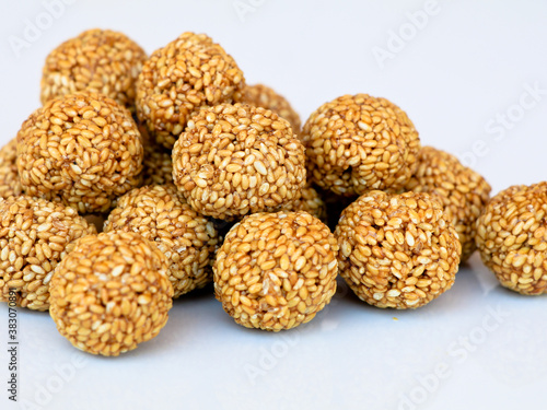 White sesame seed balls made with heated jiggery against white background