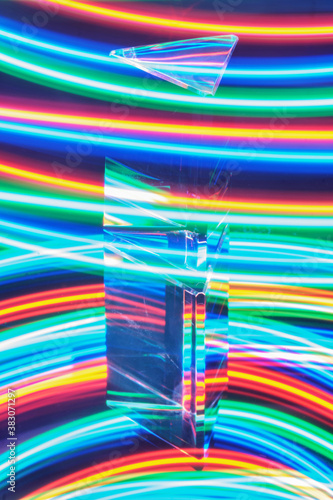 Glass Prism with reflection on a abstract colorful neon stripey background