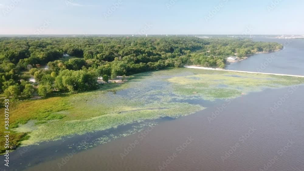 Aerial panoramic view of backwater and dike at the Lock and Dam 14 on the Mississippi River near LeClair Iowa; waterlilies, duckweed and trees along the shore Aerial panoramic view of backwater and dike at the Lock and Dam 14 on the Mississippi River near LeClair Iowa; waterlilies, duckweed and trees along the shore