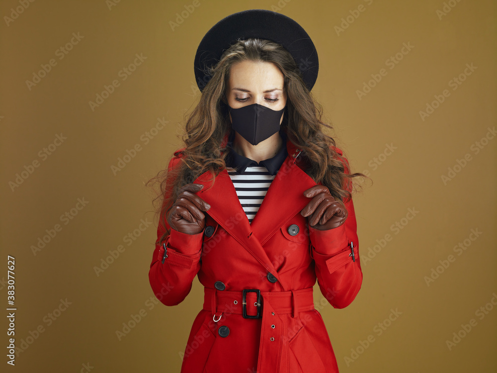 Fototapeta premium relaxed modern woman in red coat on bronze background