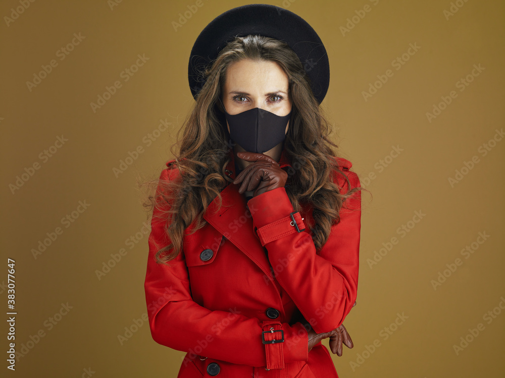 pensive stylish female in red coat against brown background pensive stylish female in red coat against brown background
