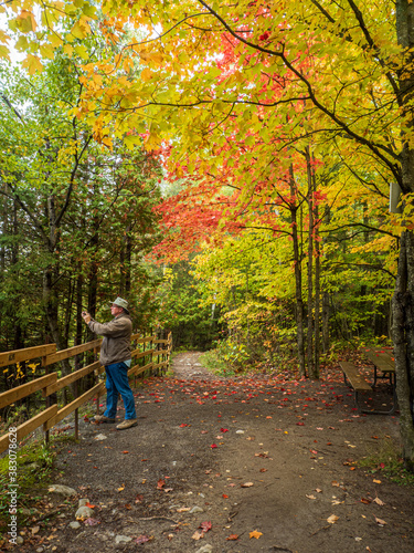 Man photographing autumn landscape with cell phone