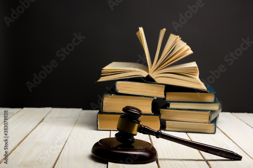 Foto Law concept - Open law book with a wooden judges gavel on table in a courtroom or law enforcement office isolated on white background