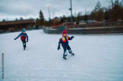 boy and girl skating together in winter