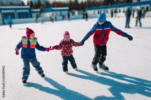happy kids skating in winter nature, family winter sport