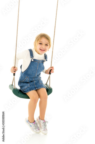 Full Length Shot of Cute Happy Girl Sitting on Rope Swing